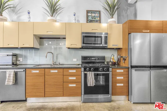 a kitchen with stainless steel appliances a stove a sink and a refrigerator