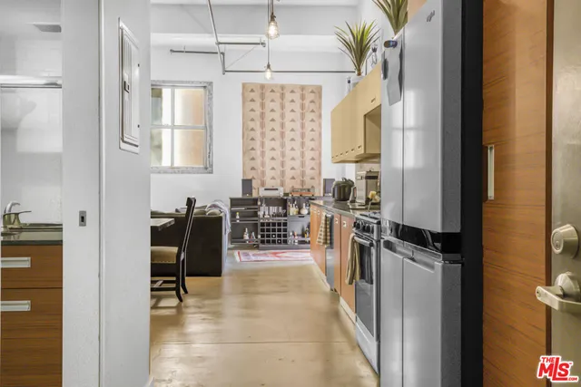 a hallway with a stove a faucet a chandelier and a dining table