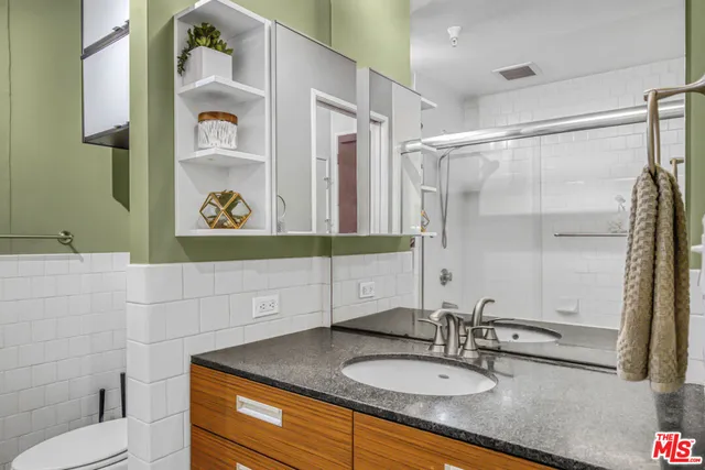 a bathroom with a granite countertop sink and a mirror