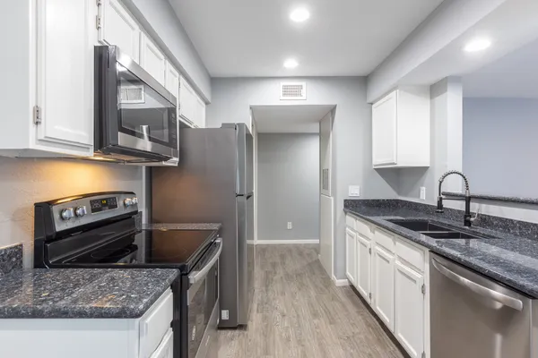 a kitchen with stainless steel appliances granite countertop a sink stove and refrigerator