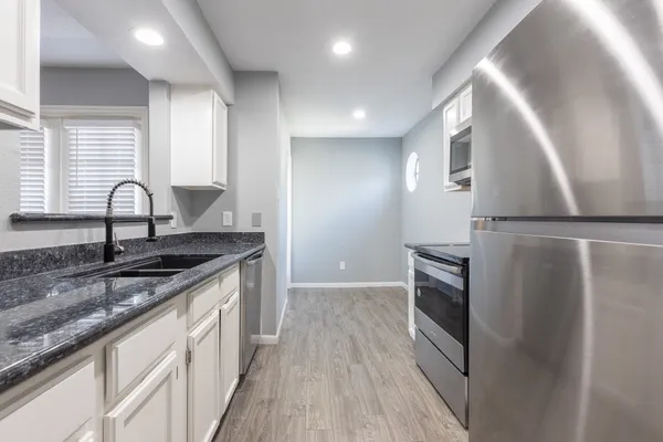 a kitchen with granite countertop a sink and a stove top oven