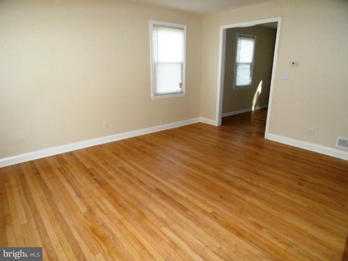 7402 Marston Road Baltimore, MD 21207 - Photo 3 of 24 an empty room with wooden floor and windows