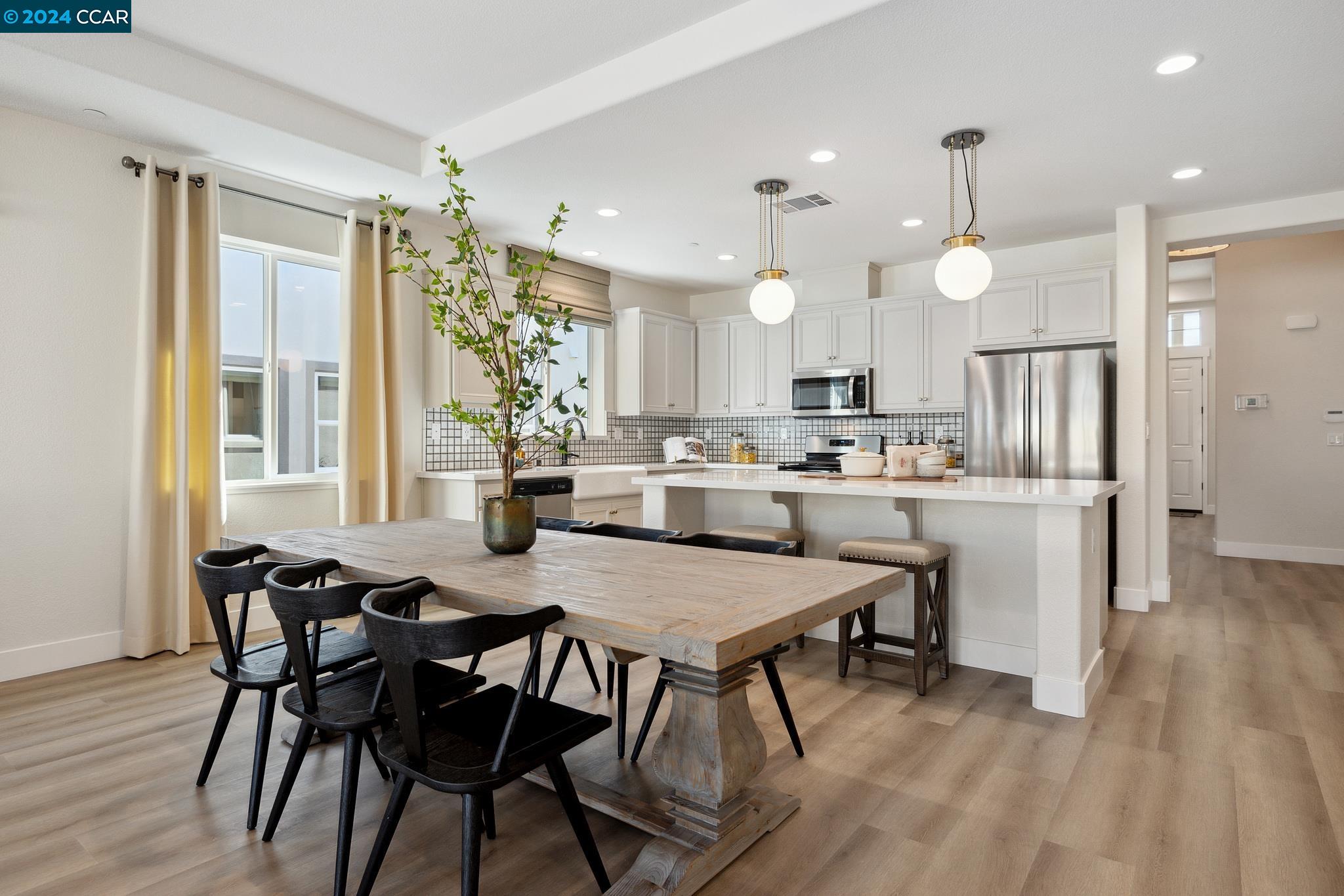 a kitchen with kitchen island a dining table and chairs