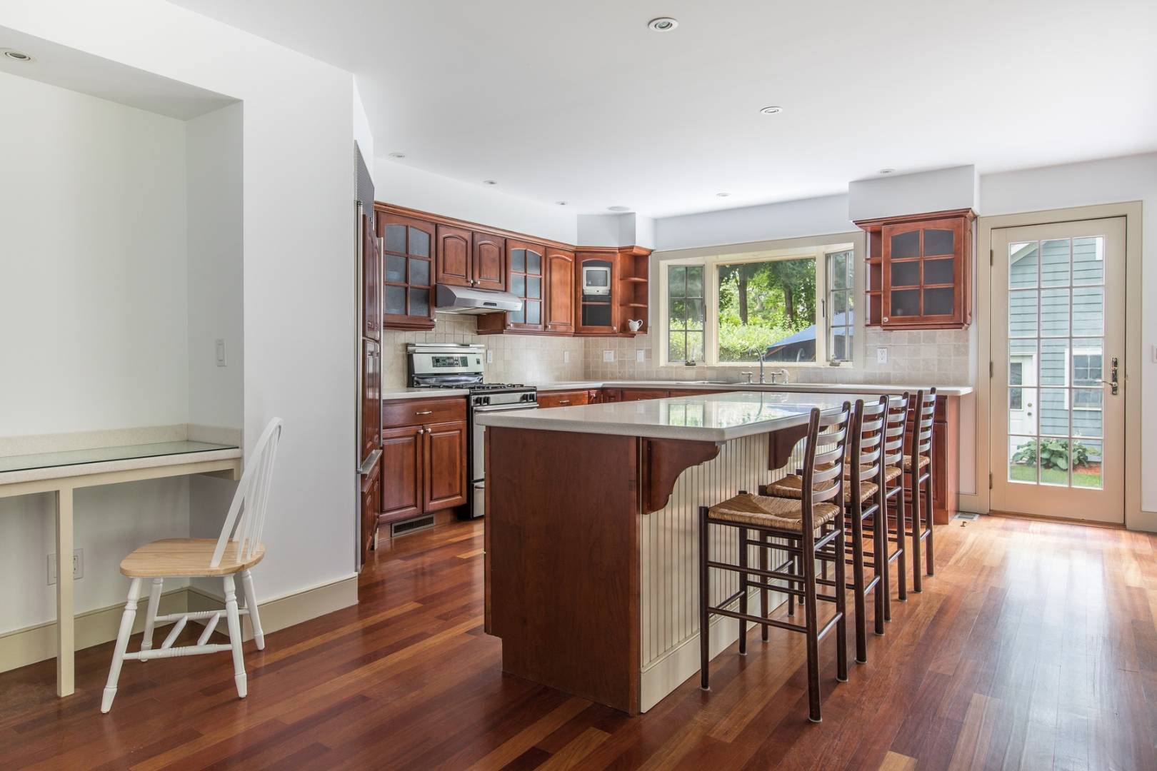15 Hamilton Street Sag Harbor, NY 11963 - Photo 3 of 10 a kitchen with stainless steel appliances granite countertop table chairs stove and wooden floor