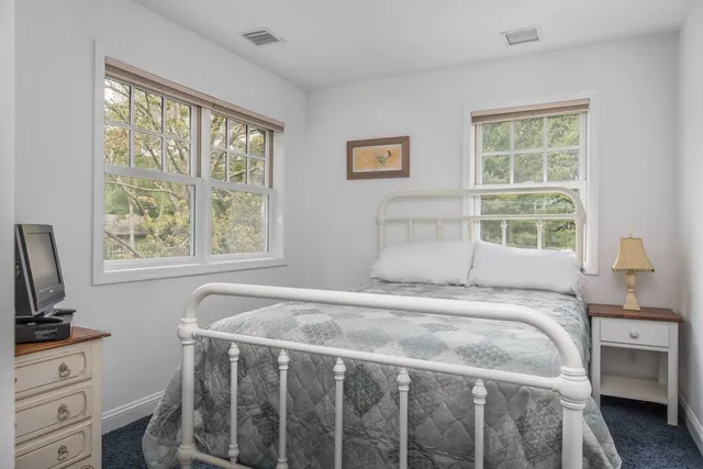 a bedroom with a bed flat screen tv and a window