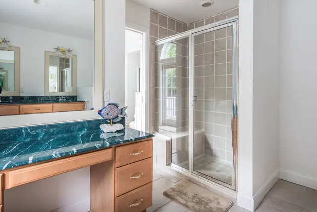 a bathroom with a granite countertop sink and a mirror