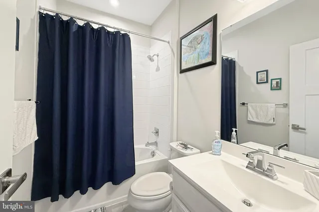 a bathroom with a sink a toilet and shower curtain