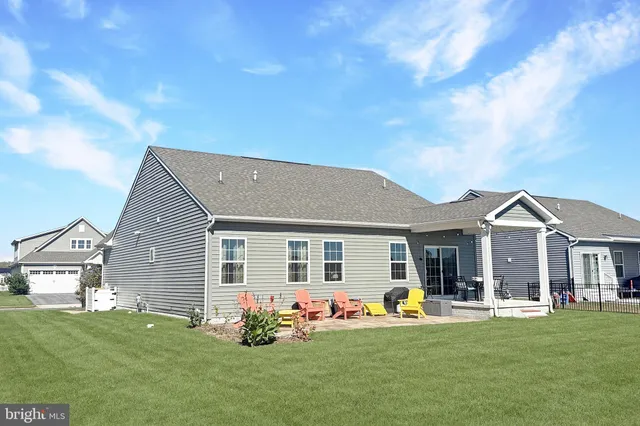 a front view of house with yard barbeque and outdoor seating