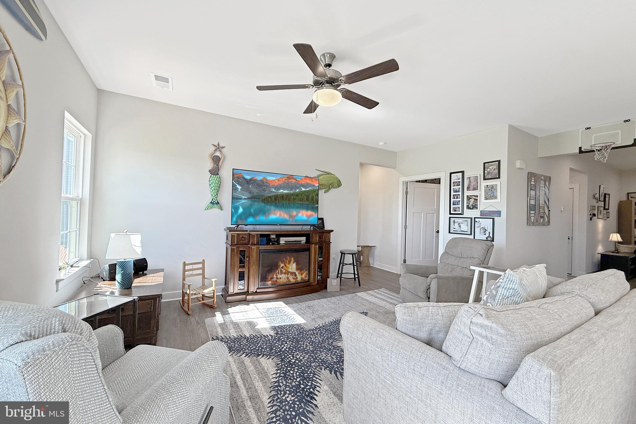 24901 Long Cove Court Millsboro, DE 19966 - Photo 7 of 23 a living room with furniture a flat screen tv and a fireplace