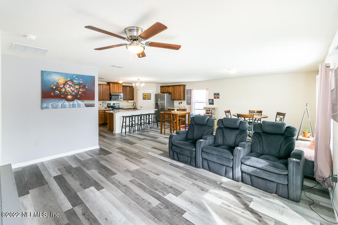 3807 Bronco Road Middleburg, FL 32068 - Photo 14 of 25 a living room with furniture kitchen view and a chandelier