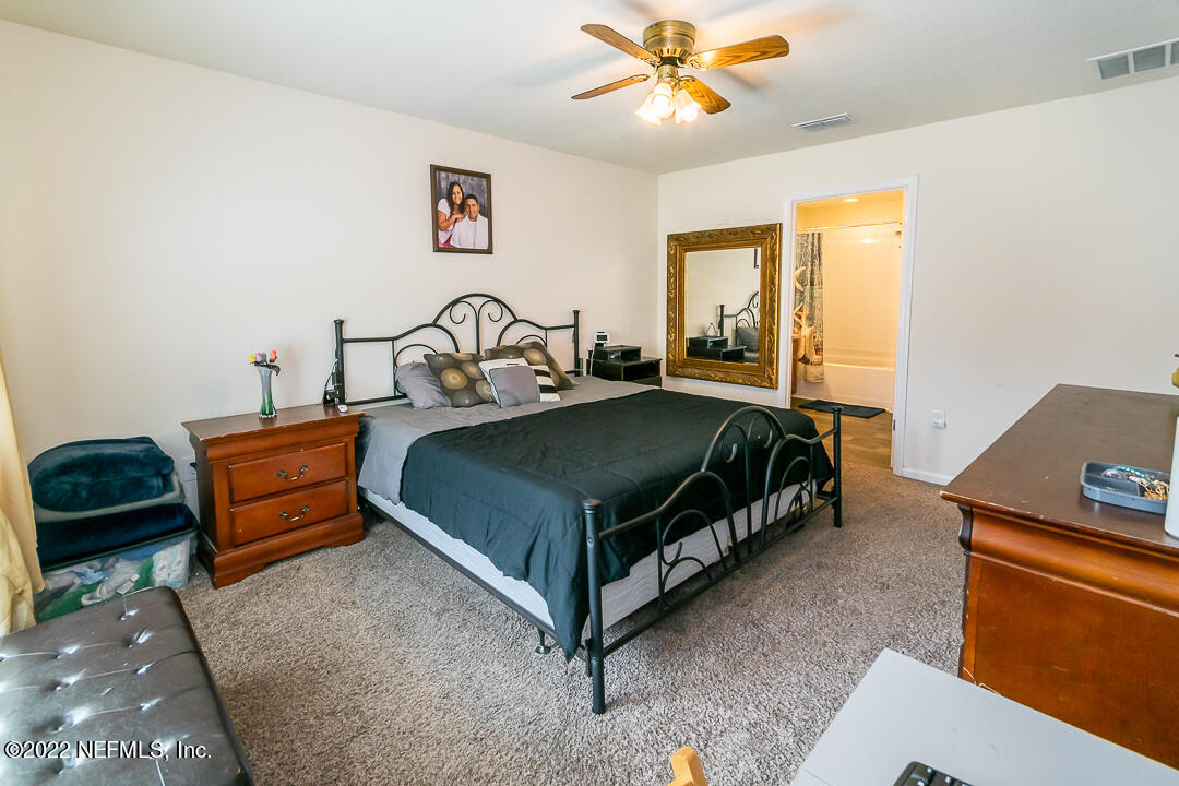 3807 Bronco Road Middleburg, FL 32068 - Photo 15 of 25 a bedroom with a bed and a chandelier