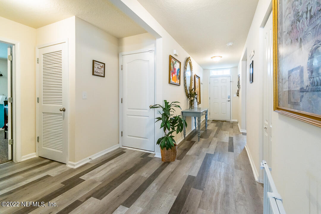 3807 Bronco Road Middleburg, FL 32068 - Photo 18 of 25 a hallway with wooden floor and a potted plant