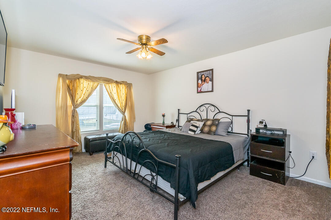 3807 Bronco Road Middleburg, FL 32068 - Photo 4 of 25 a bedroom with a bed and a chandelier