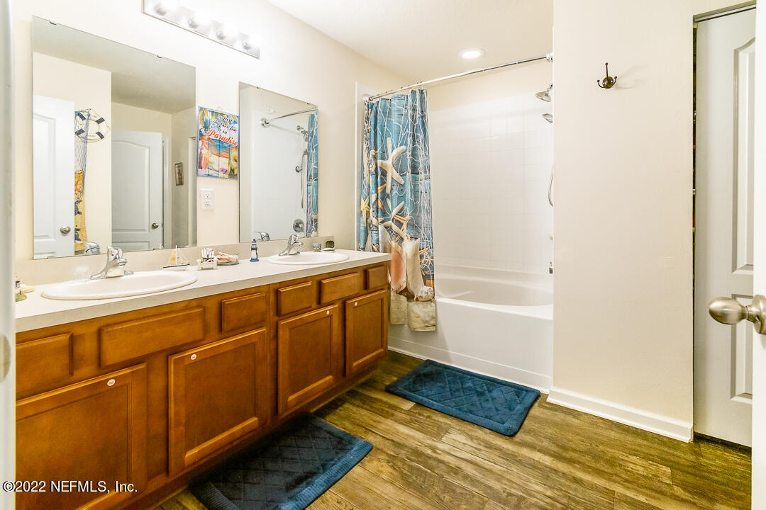 3807 Bronco Road Middleburg, FL 32068 - Photo 5 of 25 a bathroom with a double vanity sink a mirror and a bathtub