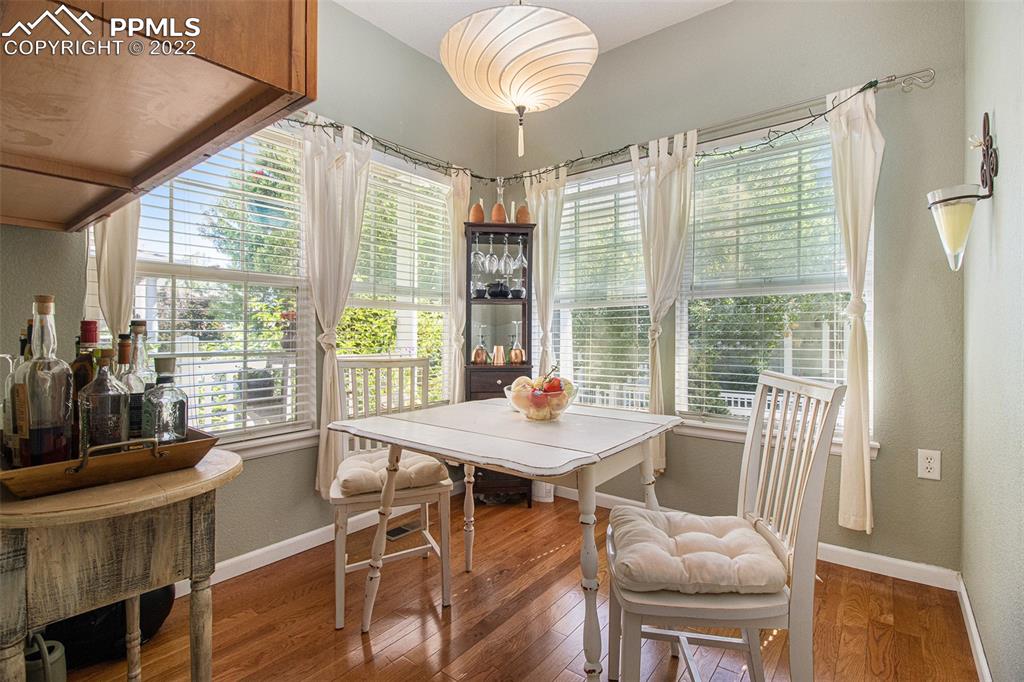 1472 Thunder Butte Road Castle Rock, CO 80109 - Photo 4 of 10 a dining room with wooden floor a chandelier a glass table and chairs