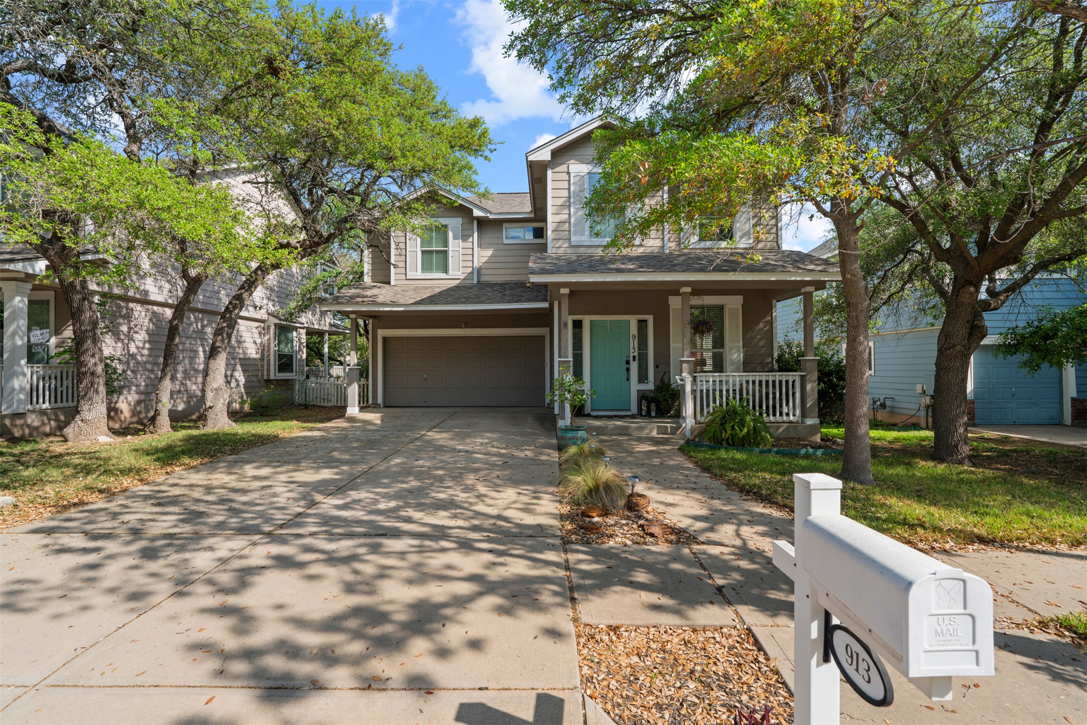 Traditional home with covered porch, driveway, roof with shingles, and an attached garage