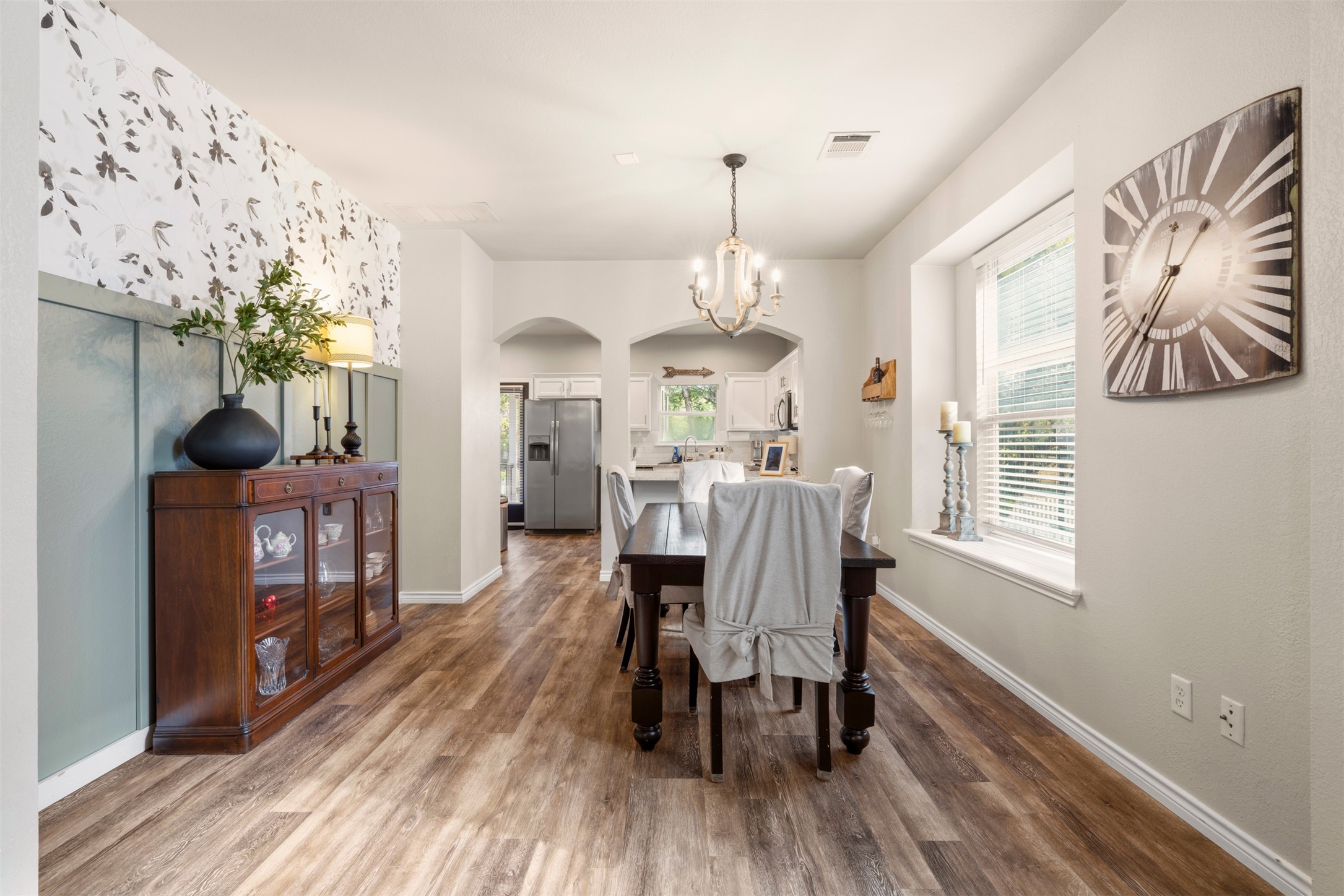 913 Bogart Road Cedar Park, TX 78613 - Photo 3 of 27 Dining area featuring arched walkways, suspended lighting, and dark wood-style flooring