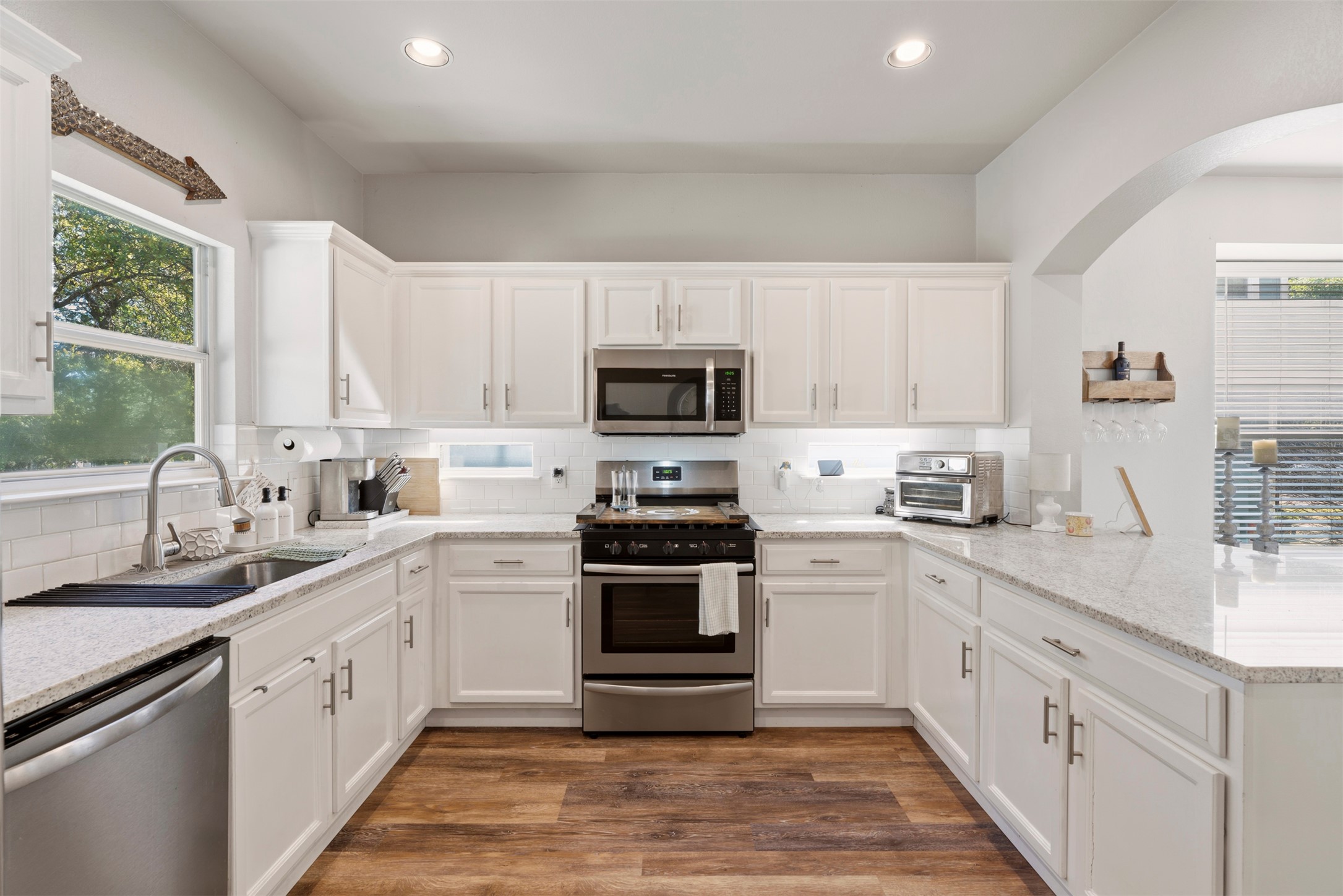 913 Bogart Road Cedar Park, TX 78613 - Photo 5 of 27 Kitchen with stainless steel appliances, white cabinetry, dark wood-style floors, light stone counters, and recessed lighting