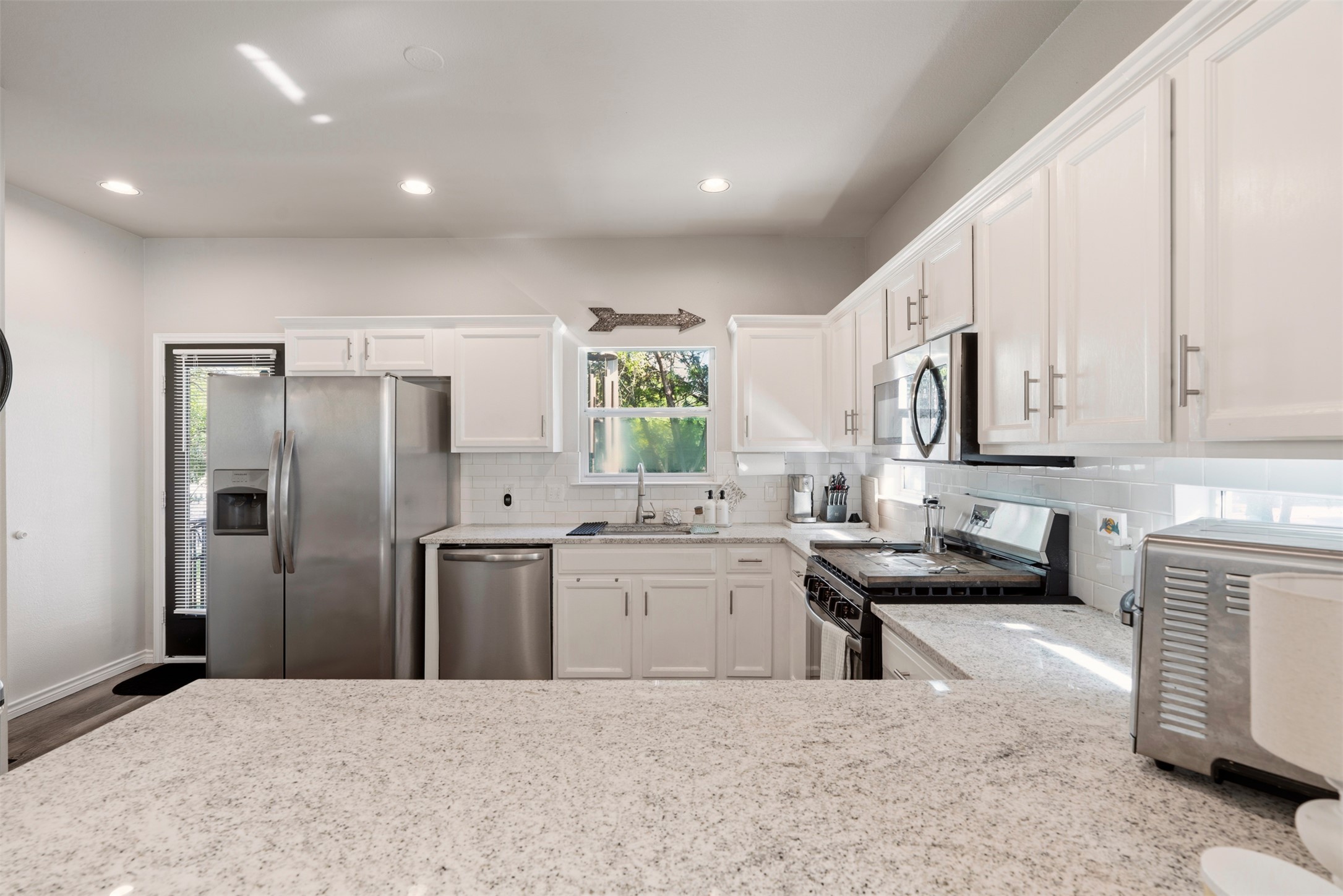 913 Bogart Road Cedar Park, TX 78613 - Photo 6 of 27 Kitchen with stainless steel appliances, white cabinets, recessed lighting, light stone counters, and tasteful backsplash
