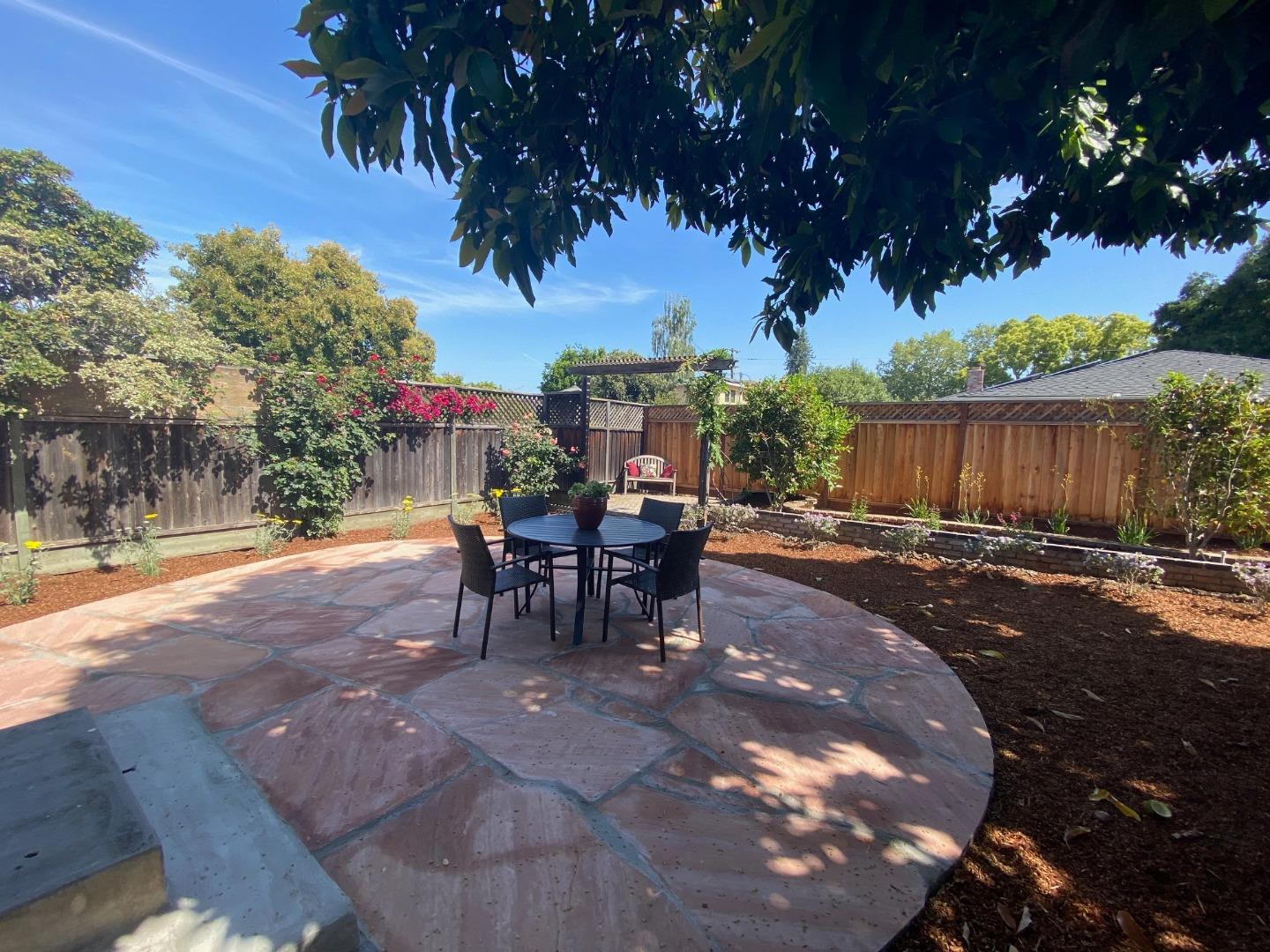 250 Vincent Drive Mountain View, CA 94041 - Photo 15 of 23 a view of a patio with a table and chairs under an umbrella with wooden fence