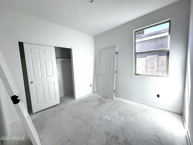 an empty room with windows and closet
