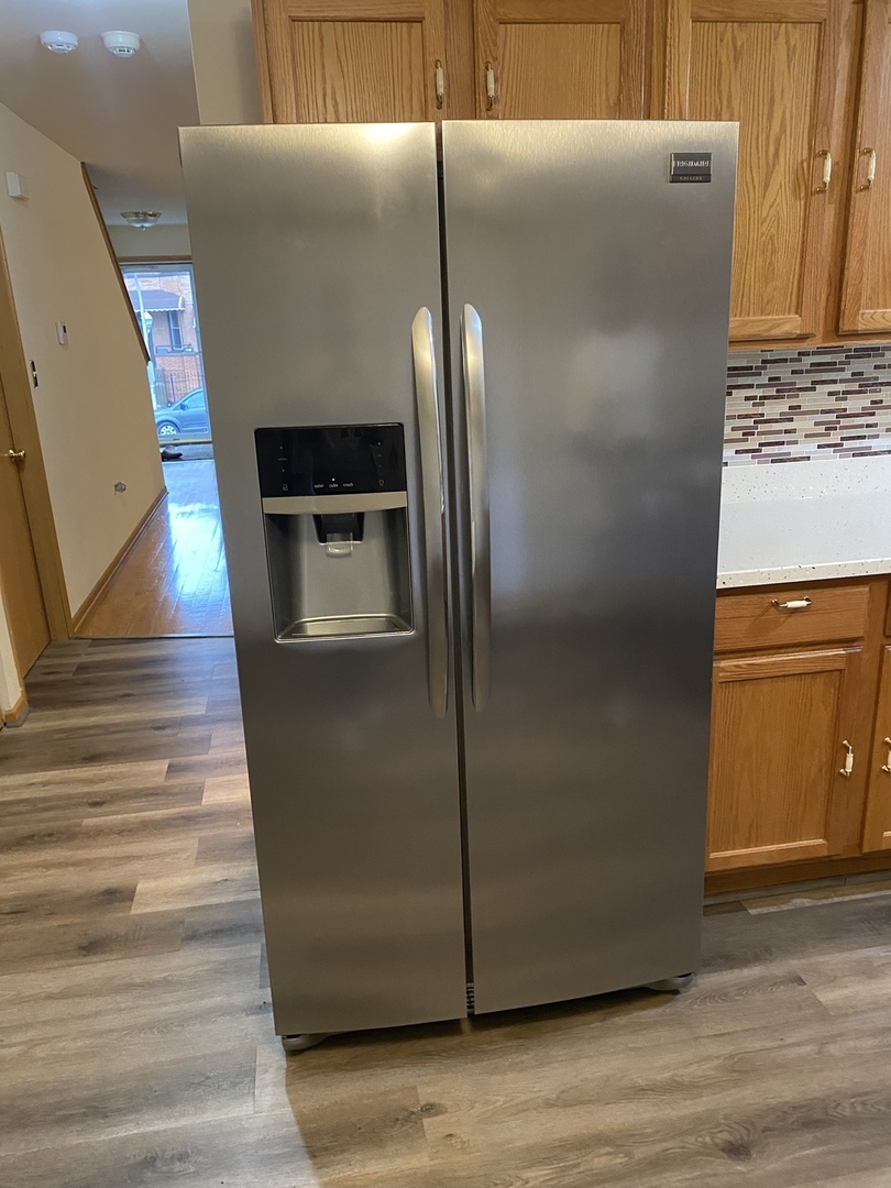 922 North Springfield Avenue Chicago, IL 60651 - Photo 11 of 47 a metallic refrigerator freezer sitting in a kitchen