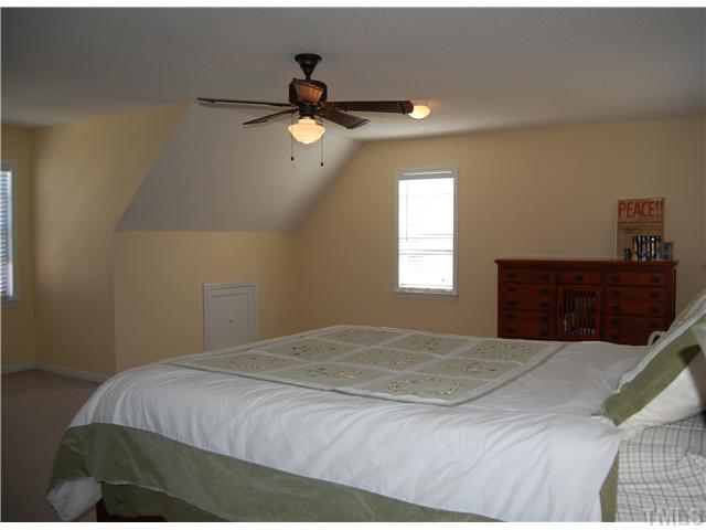 8520 Ridgebury Road Raleigh, NC 27603 - Photo 19 of 22 a bedroom with a bed and a chandelier