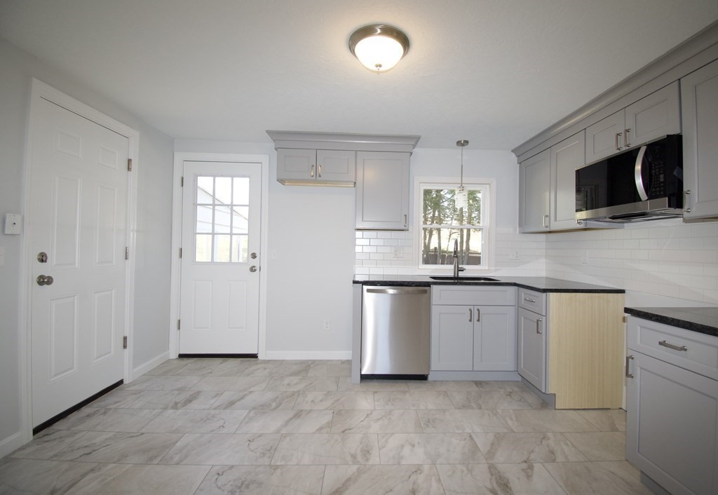 812 Maple Road Longmeadow, MA 01106 - Photo 3 of 22 a kitchen with granite countertop white cabinets a sink a window and stainless steel appliances