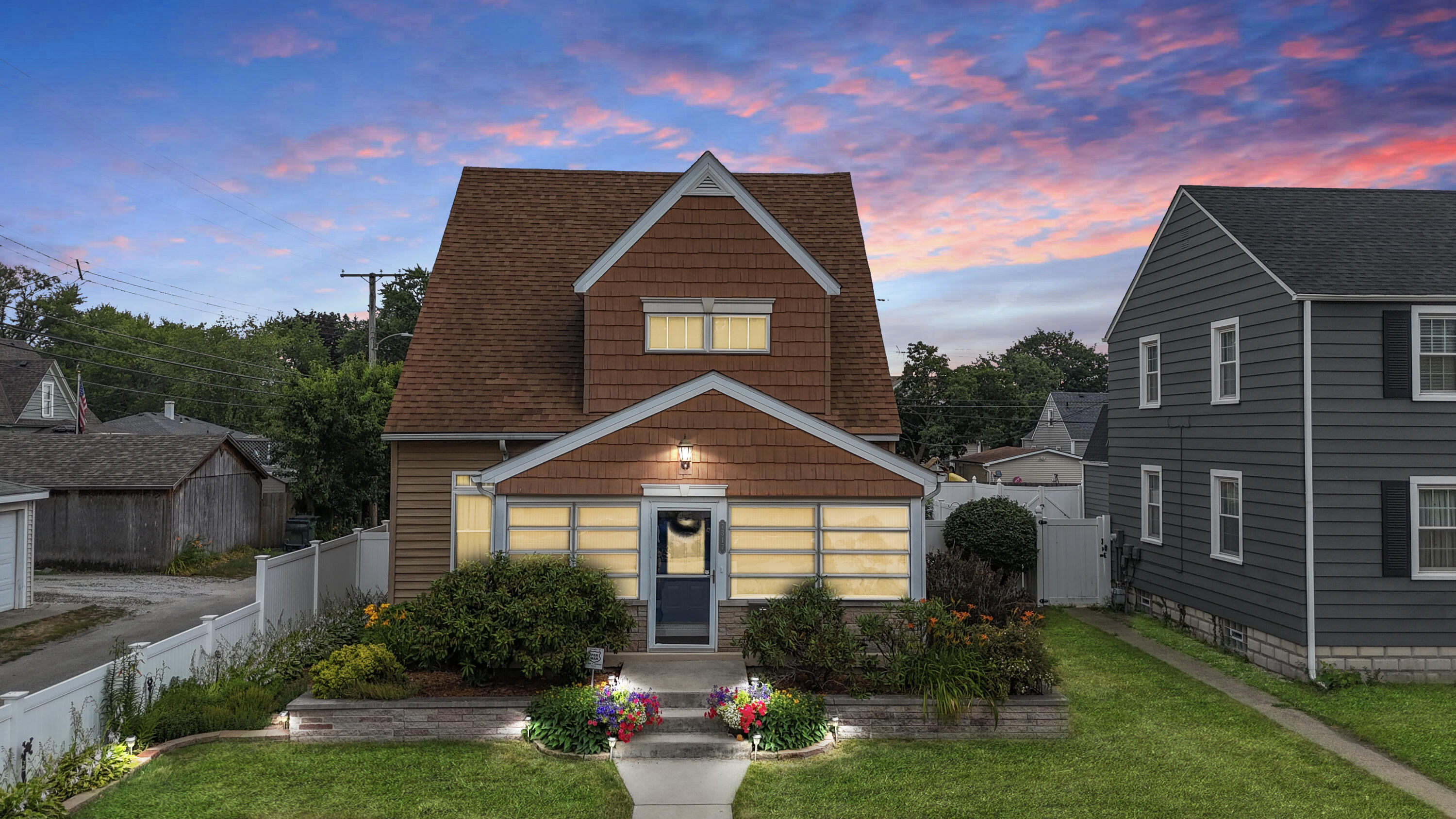 a front view of a house with a yard and potted plants