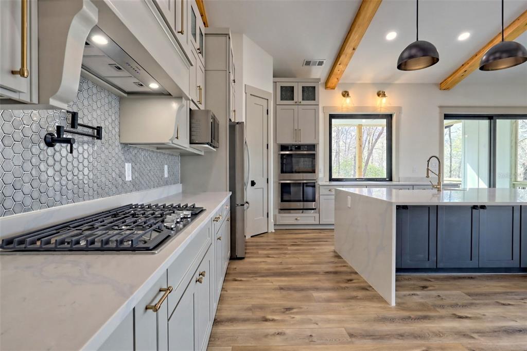 3 Plainview Road, Unit LOT 3 Odessa, FL 33556 - Photo 6 of 9 a kitchen with stainless steel appliances kitchen island granite countertop a stove and cabinets