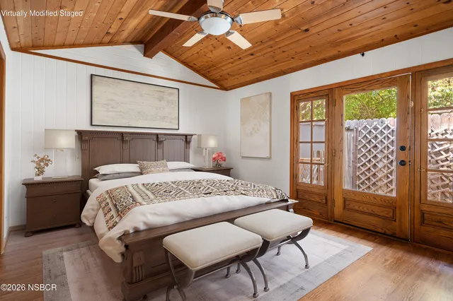 a bed sitting in a spacious bedroom next to a window