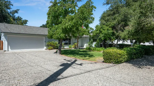 front view of a house with a yard and a trees