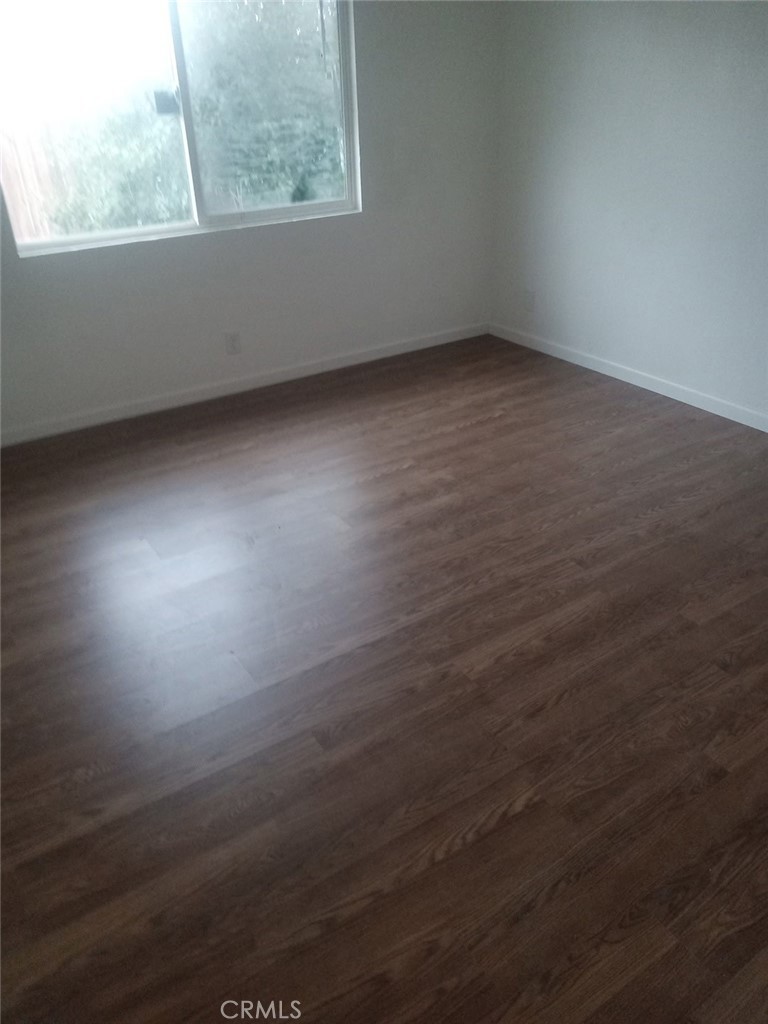 16315 Juniper Street, Unit 4 Hesperia, CA 92345 - Photo 9 of 24 an empty room with wooden floor and windows