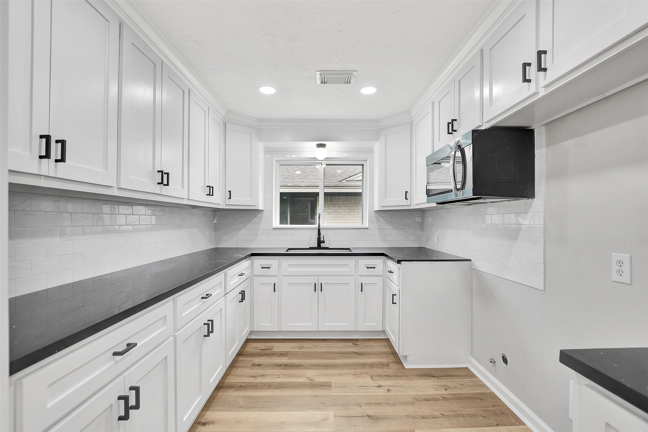 704 Teabury Street Pasadena, TX 77503 - Photo 16 of 43 a kitchen with granite countertop a sink a stove and cabinets