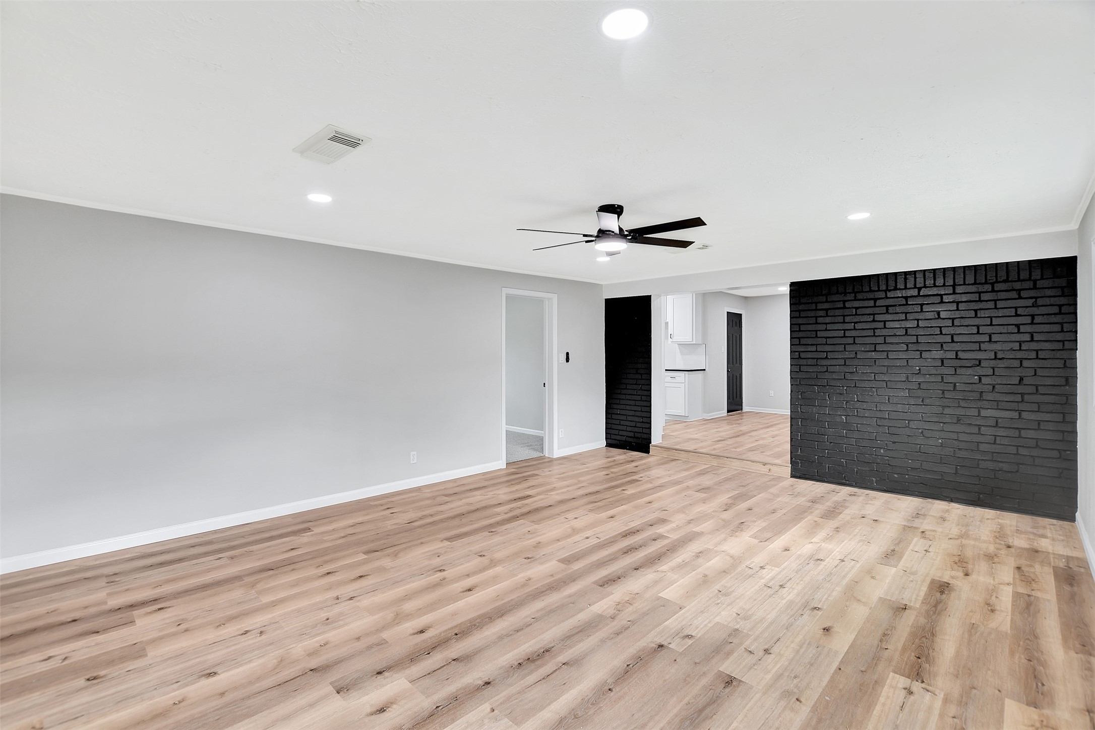 704 Teabury Street Pasadena, TX 77503 - Photo 20 of 43 a view of an empty room with wooden floor and a ceiling fan