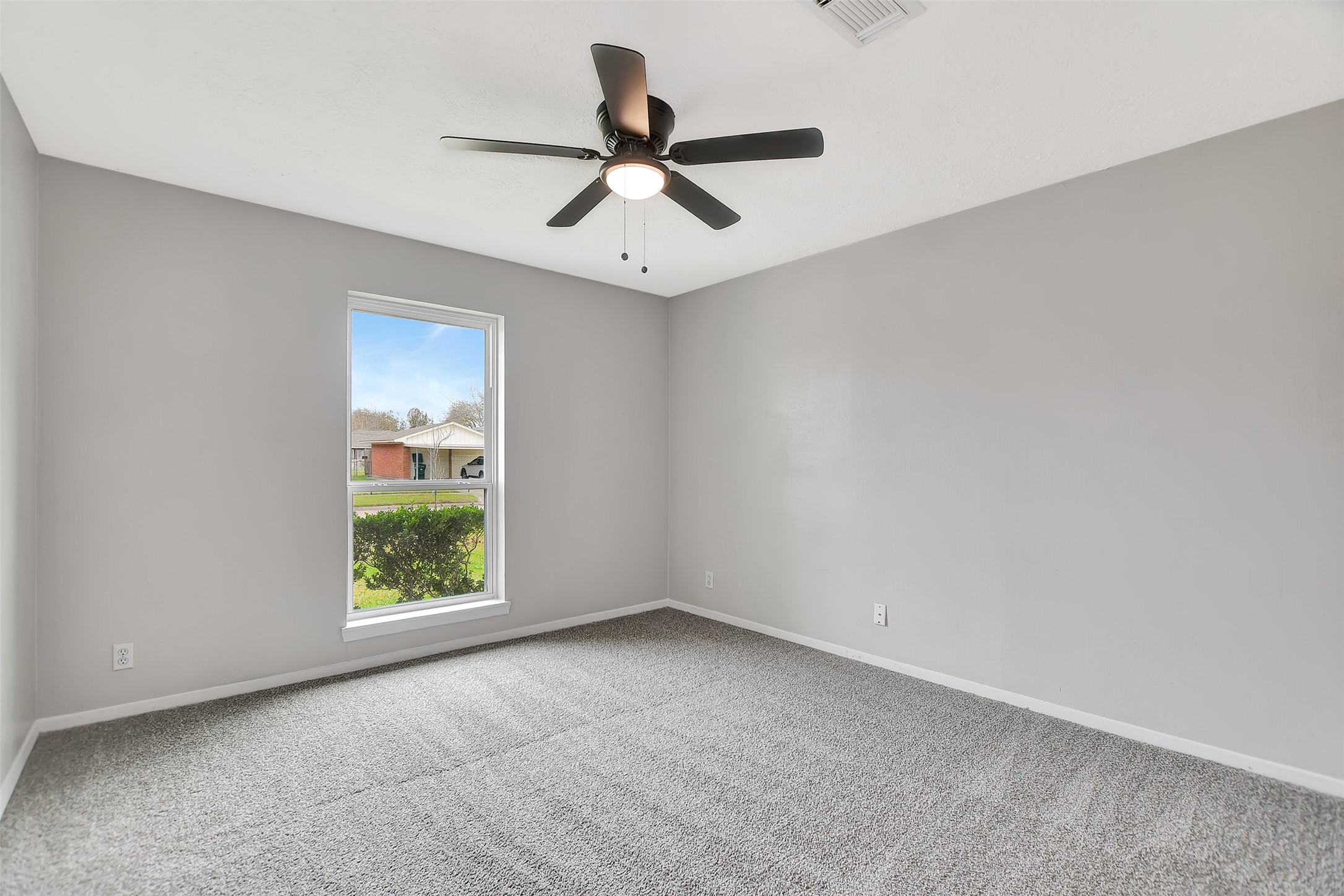 704 Teabury Street Pasadena, TX 77503 - Photo 6 of 43 an empty room with windows and ceiling fan