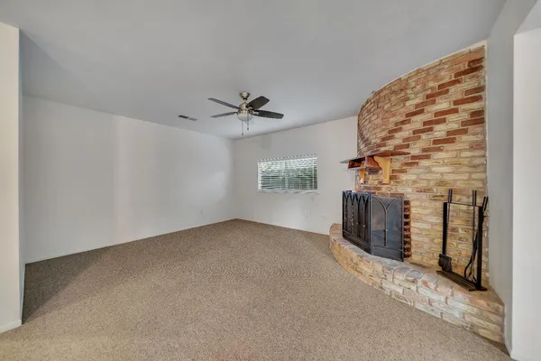 wooden floor in an empty room and a ceiling fan