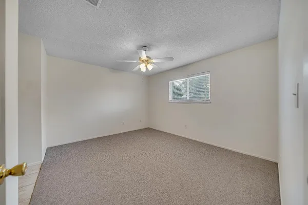 a view of an empty room with a ceiling fan