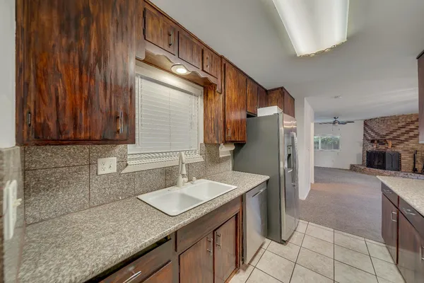 a kitchen with granite countertop stainless steel appliances a refrigerator and cabinets
