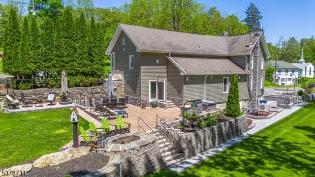 a view of house with backyard seating area and green space