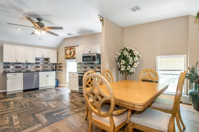 a view of a dining room with furniture a chandelier and wooden floor