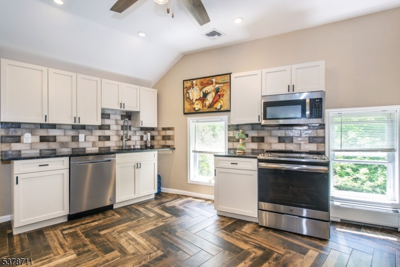 1856 Rt565, Unit 1 Glenwood, NJ 07418 - Photo 7 of 20 a kitchen with stainless steel appliances granite countertop a stove a sink dishwasher a refrigerator and a microwave oven with white cabinets