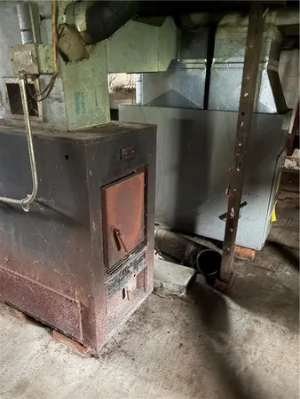 a room with water heater and wooden cabinets