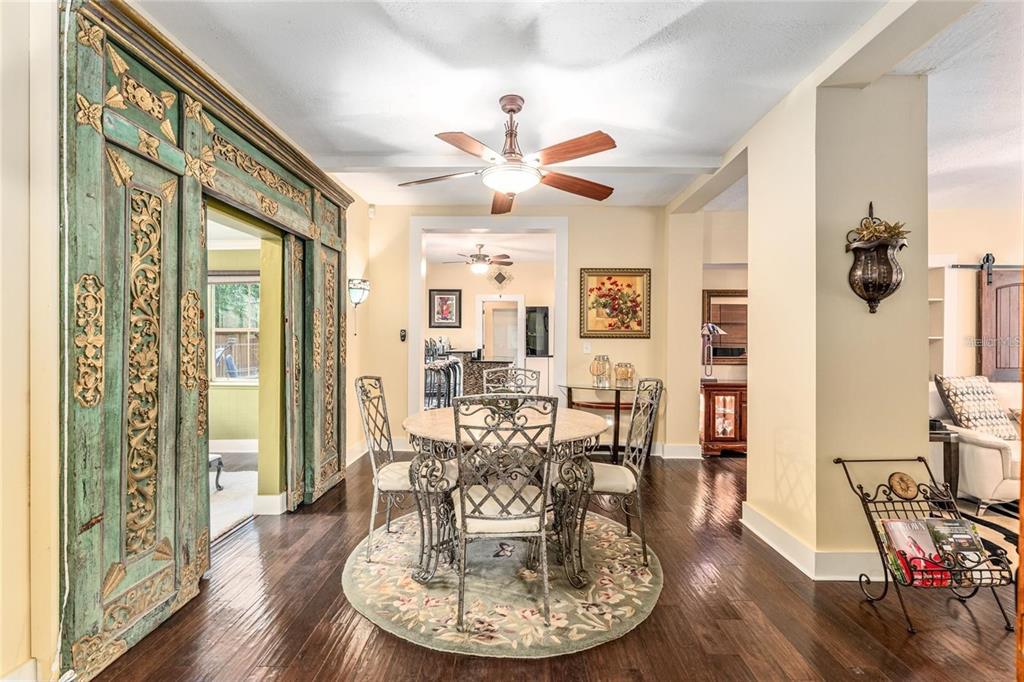 44 Southeast 8th Court Ocala, FL 34471 - Photo 23 of 87 a dining room with wooden floor a chandelier fan a wooden table and chairs