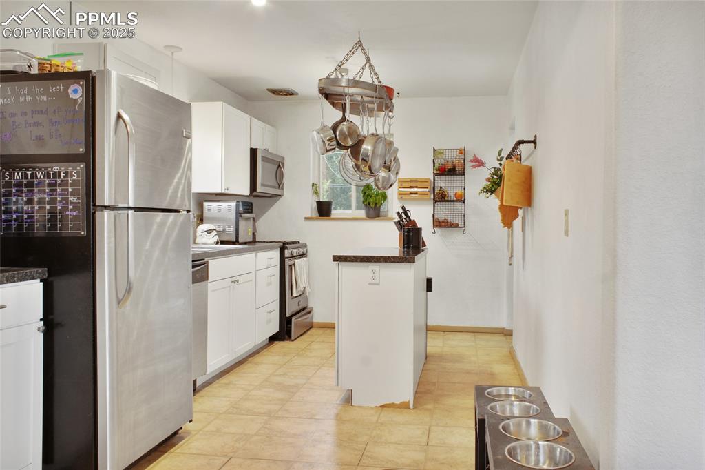 609 Placid Road Colorado Springs, CO 80910 - Photo 7 of 28 a kitchen with white cabinets and refrigerator