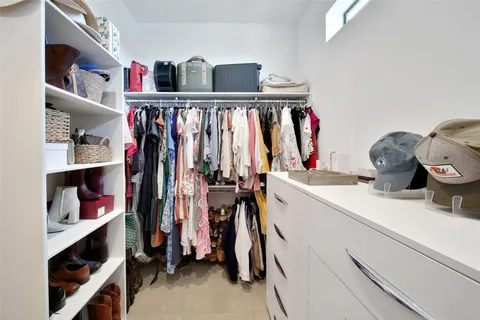 a spacious bedroom with a bed and a dresser