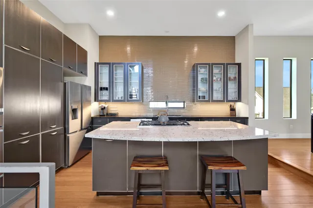 a kitchen with stainless steel appliances granite countertop a sink and a refrigerator