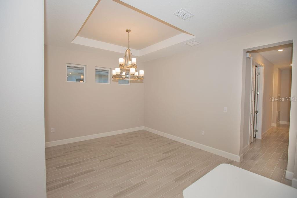 4605 Rosatti Road Wesley Chapel, FL 33543 - Photo 12 of 26 wooden floor in an empty room with a chandelier