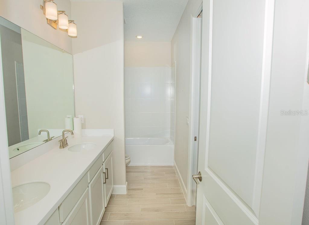 4605 Rosatti Road Wesley Chapel, FL 33543 - Photo 17 of 26 a bathroom with a double vanity sink and a mirror