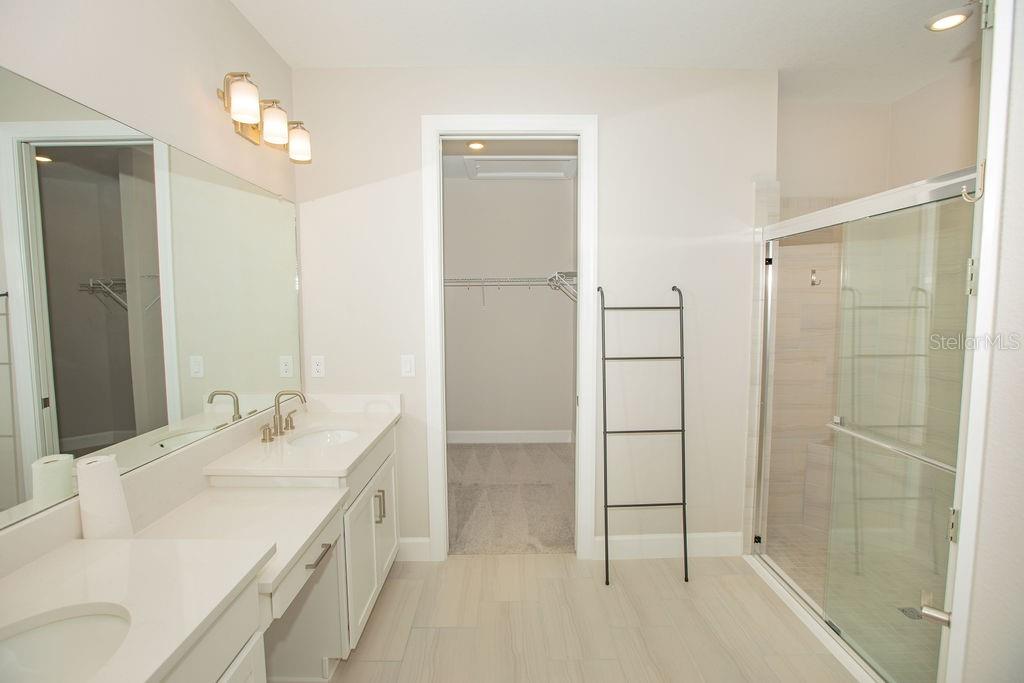 4605 Rosatti Road Wesley Chapel, FL 33543 - Photo 5 of 26 a bathroom with a double vanity sink mirror and shower